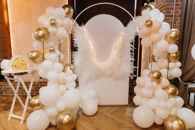 Beyaz ve altın balonlu melek kanatları fotoğraf bölgesi zarif bir parti dekoru. Yüksek kalite fotoğraf