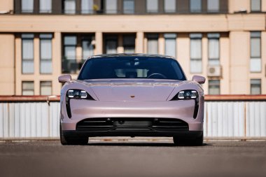 Vinnitsya, Ukrayna - 15 Temmuz 2025: Modern kentteki pembe Porsche Taycan manzarası. Yüksek kalite fotoğraf