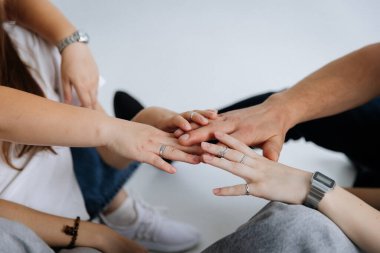 Genç arkadaşlar arka planda birlik ve destek göstererek el ele tutuşuyorlar. Yüksek kalite fotoğraf