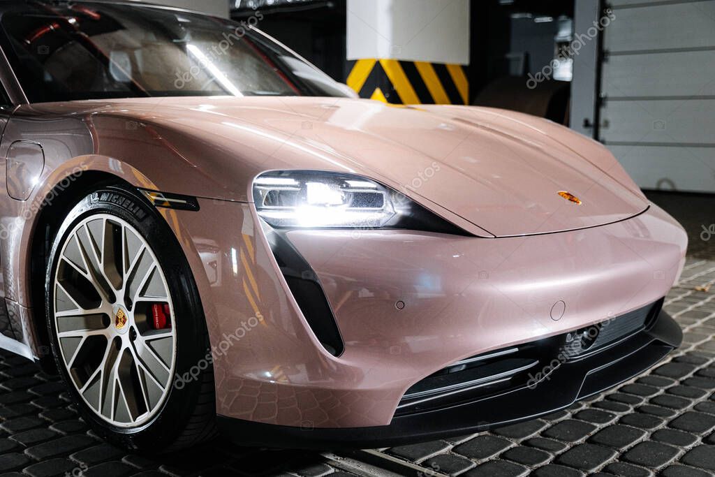 Vinitsya Ukraine 15 July 2025:Pink Porsche Taycan front corner with headlights in underground garage. High quality photo