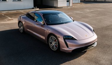Vinnitsya, Ukrayna - 15 Temmuz 2025: Pembe Porsche Taycan, boş çatı katı otoparkında, yumuşak ışıkta. Yüksek kalite fotoğraf