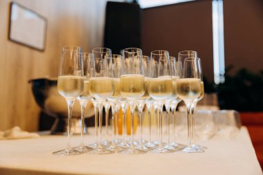 Şık bir etkinlikte şölen masasında köpüklü soğuk şampanya kadehleri. Yüksek kalite fotoğraf