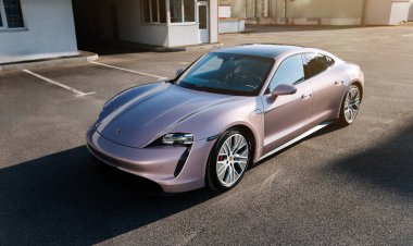 Vinnitsya, Ukrayna - 15 Temmuz 2025: Pembe Porsche Taycan, boş çatı katı otoparkında, yumuşak ışıkta. Yüksek kalite fotoğraf