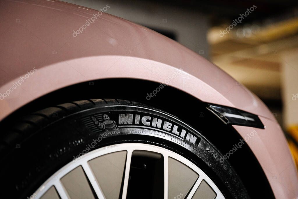 Vinnitsya, Ukraine - 15 of July 2025: Close up Michelin tire on pink Porsche Taycan wheel in garage. High quality photo