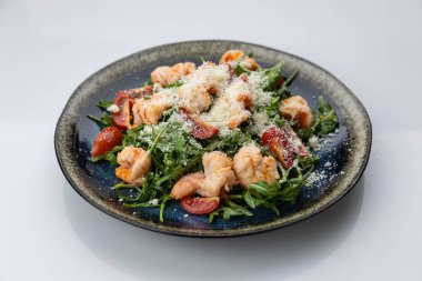 Çeri domatesli karides roka salatası ve siyah tabakta parmesan, stüdyo manzaralı. Yüksek kalite fotoğraf