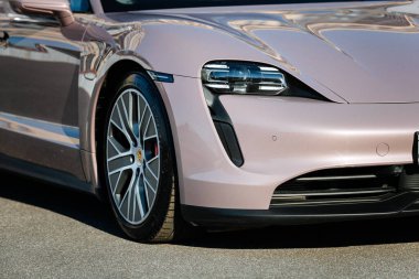 Vinnitsya, Ukrayna - 15 Temmuz 2025: Pembe Porsche Taycan ön tekerlek ve far yakın. Yüksek kalite fotoğraf