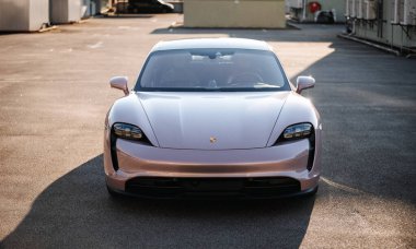 Vinnitsya, Ukrayna - 15 Temmuz 2025: Pembe Porsche Taycan, boş çatı katı otoparkında, yumuşak ışıkta. Yüksek kalite fotoğraf