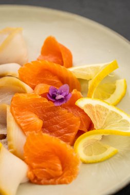 Limon dilimli somon balığı ve tabakta yenilebilir bir çiçek. Yüksek kalite fotoğraf