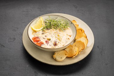 Limonlu ve mikroyeşillikli kremalı deniz ürünleri çorbası, kızarmış baget dilimleriyle servis ediliyor. Yüksek kalite fotoğraf