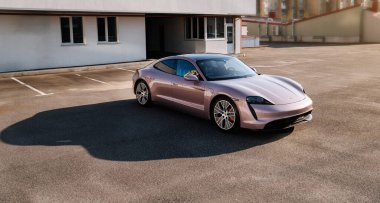 Vinnitsya, Ukrayna - 15 Temmuz 2025: Pembe Porsche Taycan, boş çatı katı otoparkında, yumuşak ışıkta. Yüksek kalite fotoğraf