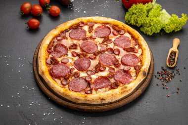 Tahtada salamlı, sosisli ve baharatlı taze pepperonili pizza. Yüksek kalite fotoğraf