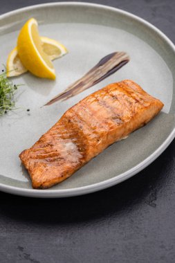 Limonlu ızgara somon fileto ve tabakta mikroyeşillik, gurme restoran tabağı. Yüksek kalite fotoğraf