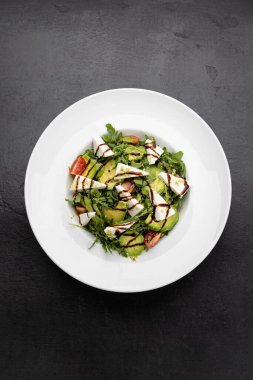 Taze avokado, roka, vişneli domates ve balzamik çiselemeli feta salatası. Yüksek kalite fotoğraf