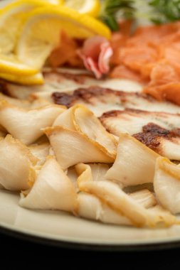Limonlu garnitürlü füme balık dilimleri, deniz ürünleri aperatifleri makrosu. Yüksek kalite fotoğraf