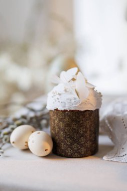 Beyaz kremalı Paskalya pastası, kelebek süsü ve yumuşak bahar ışığında yumurtalar. Yüksek kalite fotoğraf