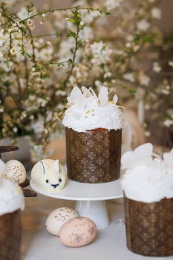 Paskalya pastası, boyalı yumurta ve tavşanlı şeker, bahar çiçeği arka planı, yumuşak ışık. Yüksek kalite fotoğraf