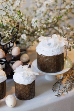Paskalya pastaları ve bahar masasında çiçek dallarıyla boyanmış yumurtalar. Yüksek kalite fotoğraf