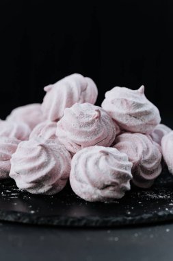 Tahta tabakta pembe kremalı kurabiye, koyu arka plan, pudra şekeri. Yüksek kalite fotoğraf