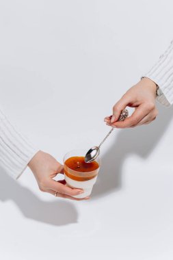 Beyaz arka planda tutku meyveli panna cotta tadında eller. Yüksek kalite fotoğraf