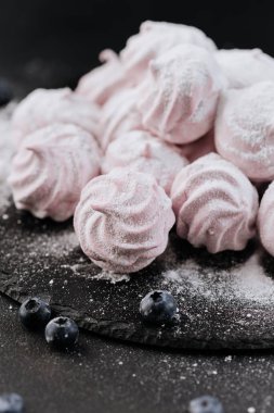 Böğürtlenli pembe kremalı kurabiye ve kayrak üzerine düşen şeker, koyu arkaplan. Yüksek kalite fotoğraf