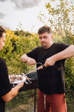 Barbeküde ızgara domuz şiş servis eden bir adam. Yüksek kalite fotoğraf