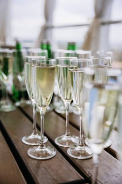 Şampanya kadehleri, ahşap masada köpüklü şarap, şenlikli bir kutlama. Yüksek kalite fotoğraf