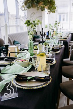 Parlak restoranda yeşil dekoru ve limonata sürahisi olan zarif bir ziyafet masası. Yüksek kalite fotoğraf