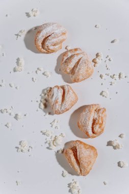 Beyaz arka planda pudra şekerli pastalar, yumuşak gölgeler. Yüksek kalite fotoğraf