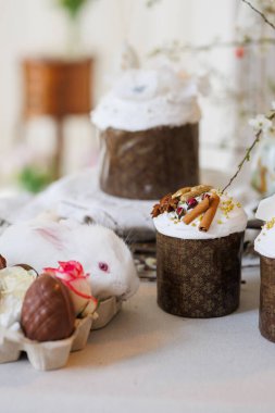 Paskalya pastalı beyaz tavşan ve çikolatalı yumurta, sıcacık bahar natürmortu, yumuşak bokeh. Yüksek kalite fotoğraf