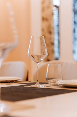 Modern yemek masasının üzerindeki zarif cam örtüyü yumuşak bokeh ve nötr tonlarla kapatın. Yüksek kalite fotoğraf