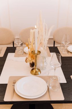 Mum ışığında yemek masası, pampa süsü ve pirinç şamdanlı. Yüksek kalite fotoğraf