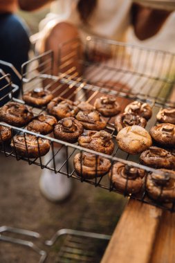 Açık hava pikniğinde barbekü sepetinde ızgara mantar, yemek çeviren eller. Yüksek kalite fotoğraf