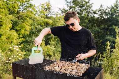 Mantar soslu adam açık havada ızgara yapıyor, yaz pikniği pişiriyor. Yüksek kalite fotoğraf