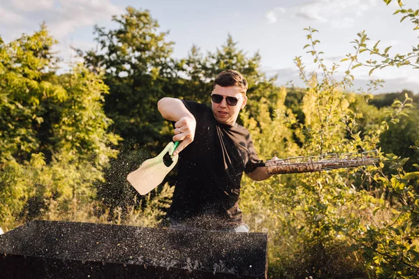 Adam gün batımında dışarıda mangal yapıyor, yaz barbeküsünde kıvılcımlar uçuşuyor. Yüksek kalite fotoğraf