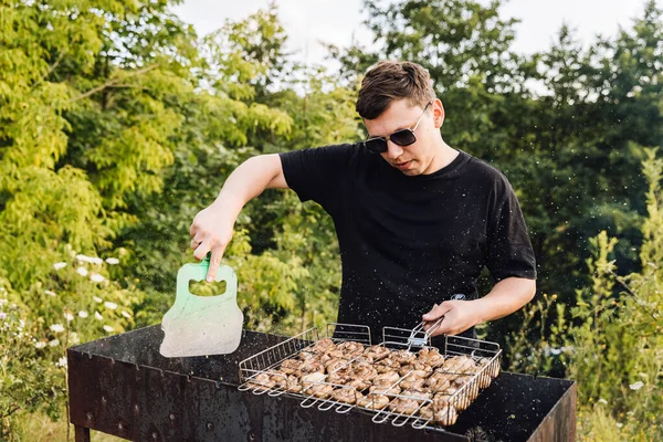 Mantar soslu adam açık havada ızgara yapıyor, yaz pikniği pişiriyor. Yüksek kalite fotoğraf