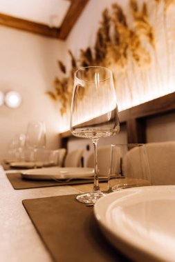 Zarif yemek masasının üzerine sıcak bir restoran ışığı olan şarap kadehini kapat. Yüksek kalite fotoğraf