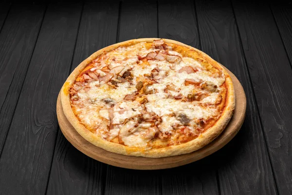 Tahta üzerinde peynirli tavuk ve mantarlı pizza, koyu arkaplan. Yüksek kalite fotoğraf