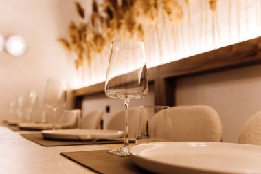 Zarif yemek masasının üzerine sıcak bir restoran ışığı olan şarap kadehini kapat. Yüksek kalite fotoğraf