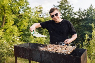Mantar soslu adam açık havada ızgara yapıyor, yaz pikniği pişiriyor. Yüksek kalite fotoğraf