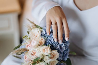 Düğün buketinde nişan yüzüğüyle gelin eli, romantik yakın plan ayrıntıları. Yüksek kalite fotoğraf