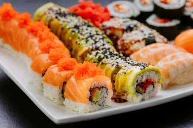 Suşi ruloları nigiri ve sashimi beyaz tabakta servis edilir. Yüksek kalite fotoğraf