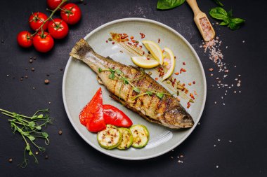 Zarif bir restoranda servis edilen sebzeli ve limonlu ızgara balık. Yüksek kalite fotoğraf
