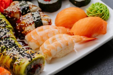 Somon karidesli ve beyaz tabakta servis edilen yakın plan suşi seti. Yüksek kalite fotoğraf