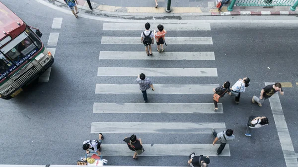 Top view a couple girl and boy with people are crossing the crosswalk in business city road.