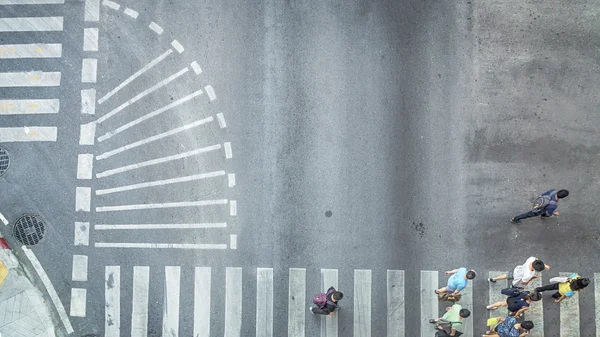 Busy city crowd move to pedestrian crossing on traffric road (Aerial photo, top view)