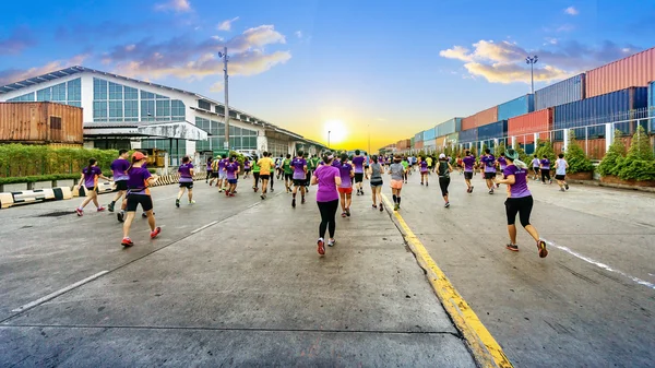 Şehir yol trafik araba sarı işareti ile ya da yaya geçidi arka plan üzerinde endüstriyel konteyner gemisi ile çalışan kimliği belirsiz maraton sporcular