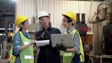 Bir grup fabrika işçisi ve kadın işçi tablet bilgisayar ve kağıt dosya raporlarıyla buluşuyor ve tartışıyorlar. Sonra da yürüyen ve konuşan kız işçiler. Sanayi fabrikasının arka planında.