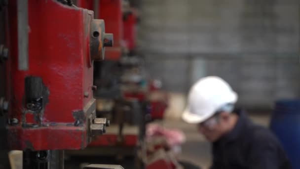 Профессиональный азиатский работник стоит и обслуживает большую машину на заводе Хранилища. Концепт-инженер с безопасностью работает и контролирует на заводе. — стоковое видео
