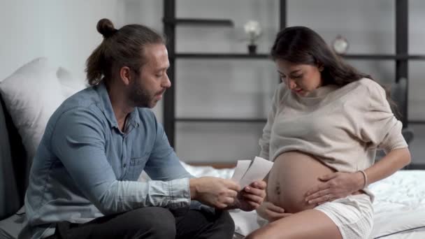 妊娠中の女性の腹を世話し 寝室で妻の腹にキスをする男 産前産後ケアと女性妊娠の概念 — ストック動画