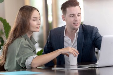 Ofiste birlikte çalışan iki profesyonel iş adamı. Biyofili ve doğa ağaçları çevresi.